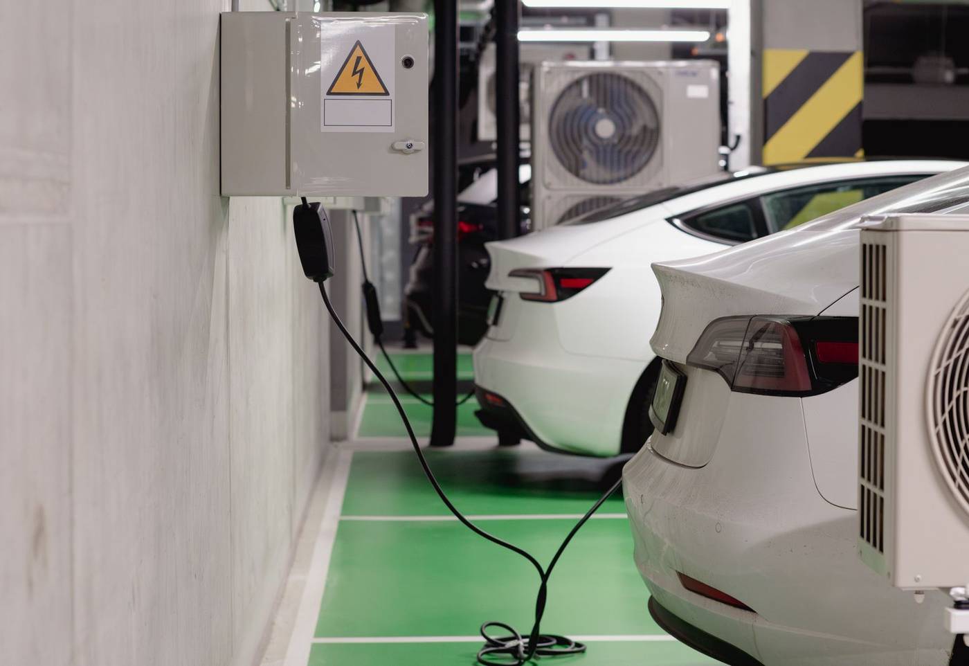 Firemné elektromobily nabíjané na parkovisku v areáli